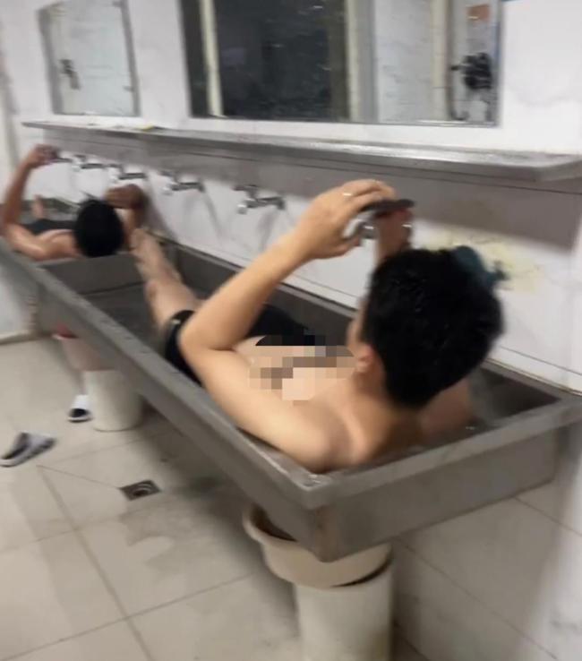 东北连日高温 学生躺卫生间水池降温