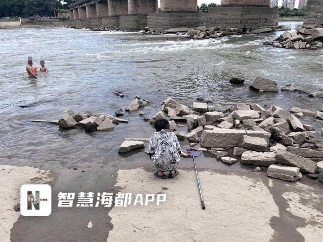 男孩被困湍急水流中众人合力营救 江边戏水隐患多